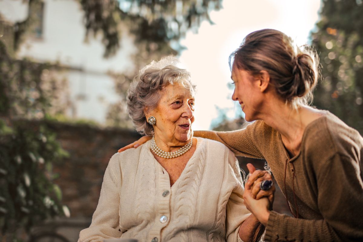 An older mother and her adult daughter smiling together — gift ideas for aging parents
