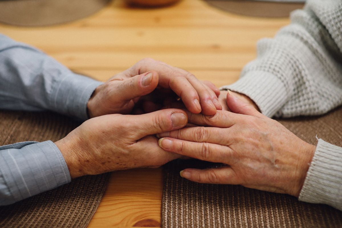 Two older hands clasped in comfort — gift ideas for family caregivers