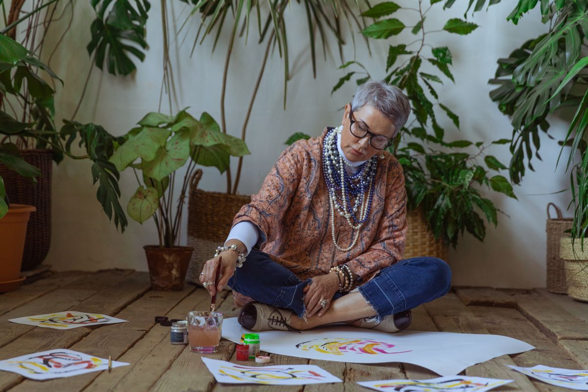 A silver-haired woman painting watercolors — retirement gift ideas for women
